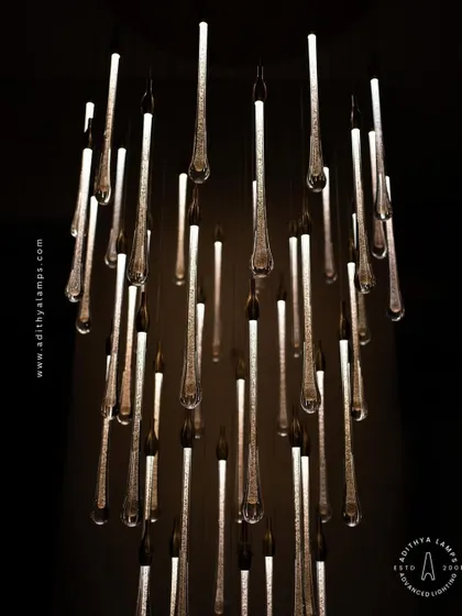 A stunning cluster of crystal teardrop pendants. Each pendant contains bubble-like inclusions that catch the light, creating a sparkling, rain-like effect. This is an elegant choice for double-height foyers or modern staircases.
