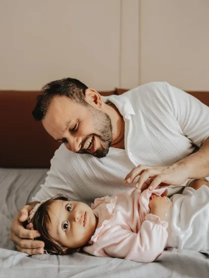 A playful moment between a father and his daughter. In-home lifestyle sessions are perfect for capturing your family in your most comfortable environment.