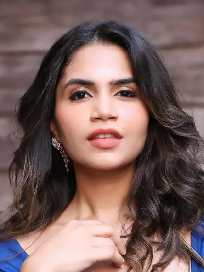 A close-up portrait showing the subtle gold shimmer on the eyes and the perfectly defined brows that frame her face.