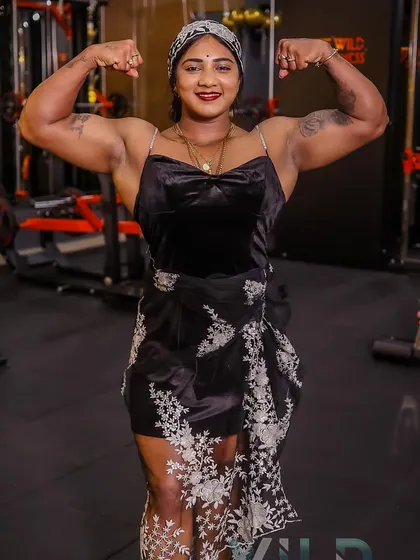 A double bicep pose for the camera at a gym event. It's important to always be ready to inspire and showcase the results of hard work.