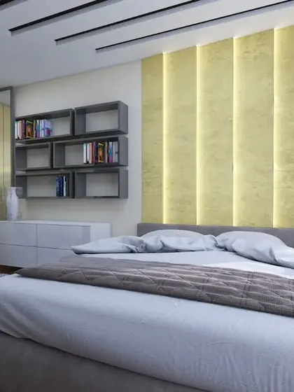 This bedroom features a striking gold-textured accent wall with integrated vertical lighting for a warm, ambient glow.