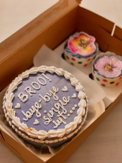 Say "bye-bye single life" with this fun bachelorette or bridal shower combo. The lavender-colored bento cake is paired with two cupcakes decorated with beautiful, edible painted flowers.