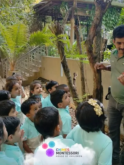 A guide at Discovery Village shows the children a flower, connecting them with nature and providing a real-world botany lesson.