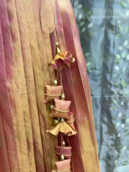 A close-up of the custom tassels we created for the peach lehenga, using the same fabric for a perfectly coordinated, high-end finish.