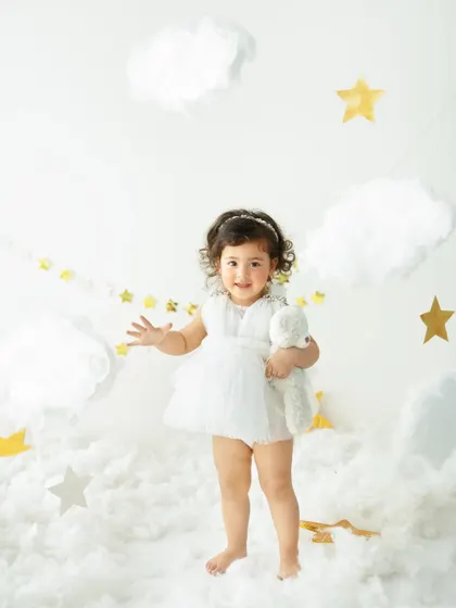 For those who dream a little bigger, I create magical themed sessions. This 'Dreamland Under the Stars' setup transforms my studio into a celestial fairytale, with fluffy clouds and golden stars, making your little one the star of their own story.