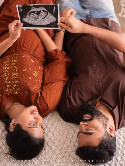 A creative overhead shot of the couple with their ultrasound picture, a wonderful way to include the baby in the portrait.
