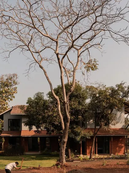 The exterior of Maison Rouge, a vacation home in the Konkan region, viewed from its garden. The design combines the rustic charm of a traditional farmhouse with modern architectural lines, creating a home that is both nostalgic and contemporary.