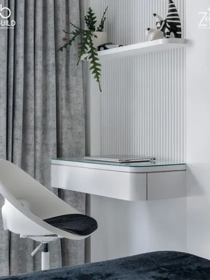A minimalist study corner in 'The House of Arcs', featuring a sleek floating desk, a modern chair, and a simple shelf, all set against a wall with fluted details.