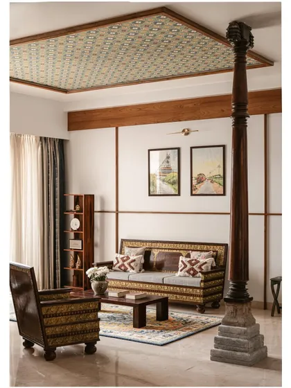 This view shows how we balance different elements in one space. The family's antique sofa set is grounded by a patterned rug, while a reclaimed wooden pillar adds structural character. Above, a ceiling inset with traditional tiles draws the eye upward, creating a room that is rich in detail and history.