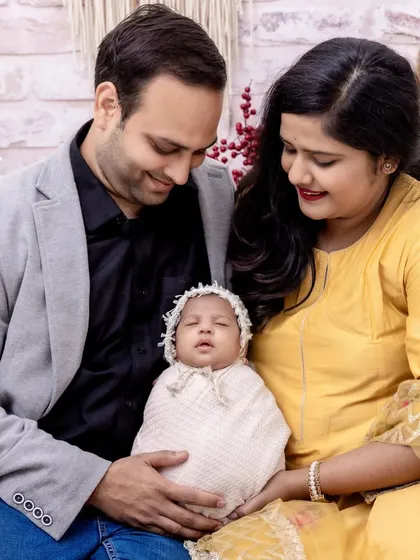 A full family portrait with a sleeping newborn, swaddled and cozy. We coordinate outfits and backdrops to create a harmonious and polished look for your first family photos.