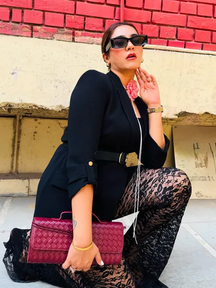 A powerful pose in a powerful outfit. The combination of a structured blazer and delicate lace pants creates a beautiful play of textures, making this a standout look for any event.