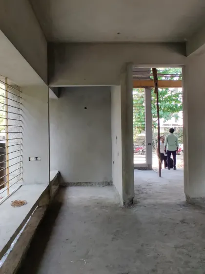An interior view of the villa during the construction phase, with large window openings already defining the connection to the outdoors.