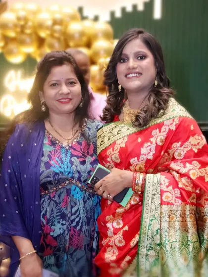 Two female guests in beautiful traditional attire smile for the camera.