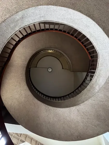A view looking down the spiral of the Nehru Centre staircase. The design creates a mesmerizing vortex, demonstrating how structural elements can become powerful artistic expressions within a building.
