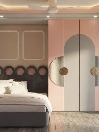 This kids' room design is all about playful geometry. The pink and grey theme is carried through the room with circular motifs on the headboard and curved, overlapping panels on the wardrobe doors.