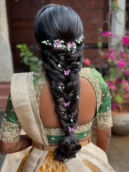 A beautiful shot of the butterfly braid against a backdrop of pink flowers, creating a perfect color harmony.