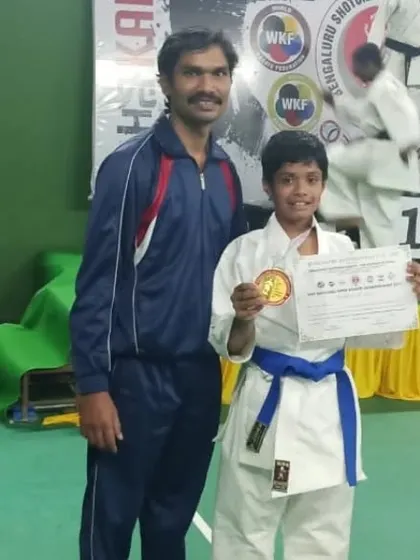 A student proudly shows his gold medal and certificate from the 2nd Kempegowda Cup 2022 National Open Karate Championship.