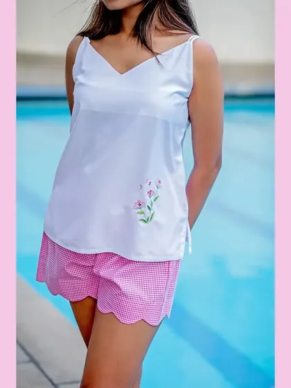 To show the versatility of the collection, we did a poolside shoot. This image of a white camisole and pink gingham shorts shows that the brand's pieces are perfect for lounging by the water, not just for sleeping.