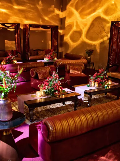 A cozy lounge setting with rich velvet sofas and ambient floor lighting, creating a warm and inviting corner.