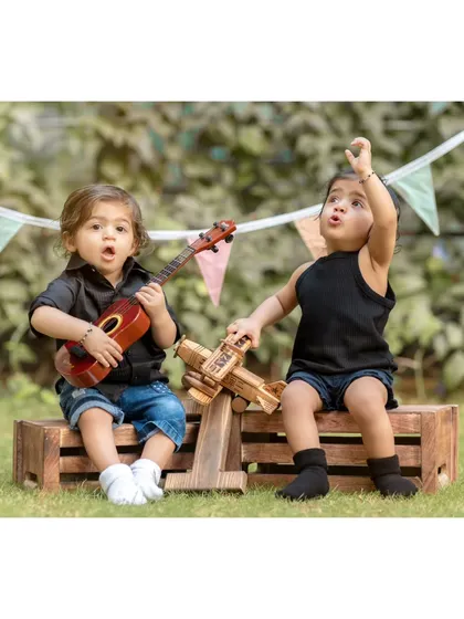 A pre-birthday jam session for these adorable twins. Using props like a ukulele and a wooden airplane, we created a playful scene that shows off their budding personalities and the fun we have during our outdoor shoots.