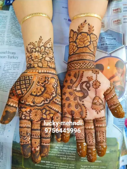 Two different yet coordinated designs for a guest. One hand has a peacock and hanging bell (jhumki) motif, while the other features a floral and paisley pattern.