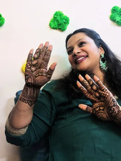 Another happy client moment. Her joy is evident as she admires her beautiful henna design.