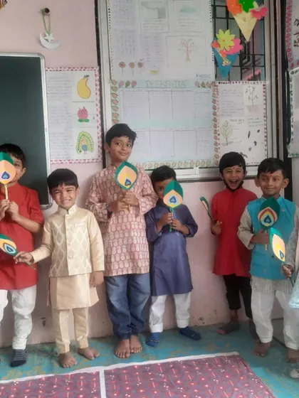 The boys proudly show their peacock feather crafts, a symbol associated with Lord Krishna. This connects their art directly to the story of the festival.