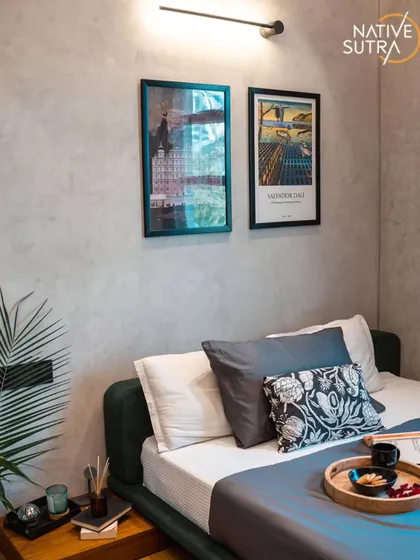 A close-up of the bedside area, showing the linear wall light and framed art that add a personal touch to the minimalist design. The textures and tones are carefully chosen to create a calm and inspiring mood.