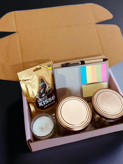 Another variation of my budget-friendly box, this one includes two jars, a candle, a notebook with a pen, and a packet of Hershey's Kisses, perfect for bulk orders.