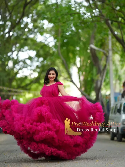 This vibrant magenta ruffled gown is full of energy and fun. The twirling motion shows off the incredible volume and playful texture of the tiered ruffles.