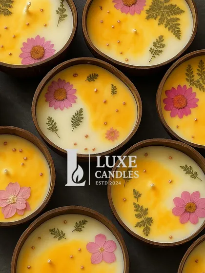 A top-down view of the coconut shell candles, showing the beautiful arrangement of dried flowers on the wax.