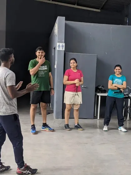 A coach provides instruction to a group of new players during a Squash Open House. These sessions are designed to introduce the basics of the game in a fun setting.