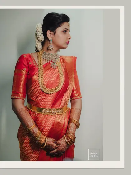 A classic, elegant side-profile portrait of the bride in her red wedding saree.