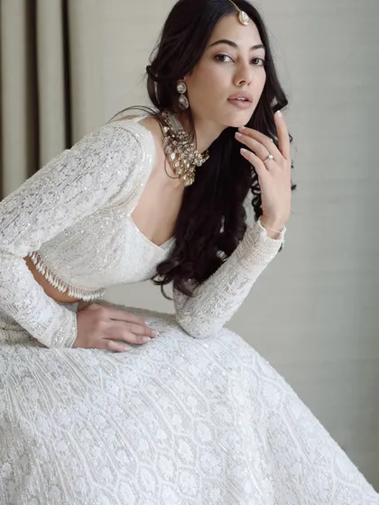 A stunning portrait of the bride, Julia, in her white Manish Malhotra lehenga. Her pose and expression exude the confidence and style of a magazine editorial.