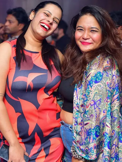 Two friends sharing a laugh at Hydra Club. The best nights are filled with good music and even better company.