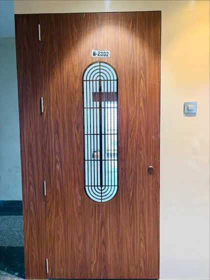 A simple yet elegant safety door with a wood finish and a vertical grill. The design is clean, modern, and secure.