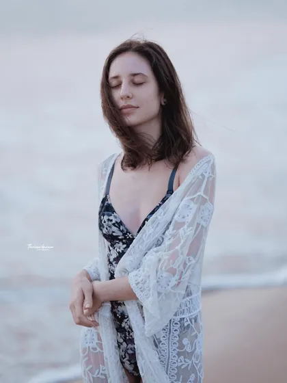 A serene portrait with eyes closed, conveying a sense of peace and connection with the ocean.