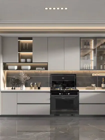 This modern kitchen features handleless cabinets, a built-in gas hob, and integrated ovens. The design uses a neutral color palette and under-cabinet lighting to create a clean and sophisticated look.
