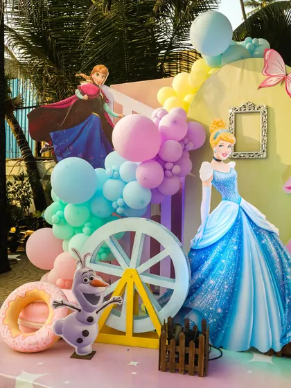 A detailed view of the princess stage, featuring cutouts of Cinderella, Anna, and Olaf alongside a decorative ferris wheel.