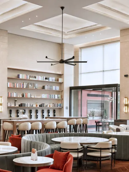 A view of the bar and lounge area at the Elevate Clubhouse. The combination of warm lighting, comfortable seating, and open shelving creates a sophisticated yet relaxed atmosphere for residents.