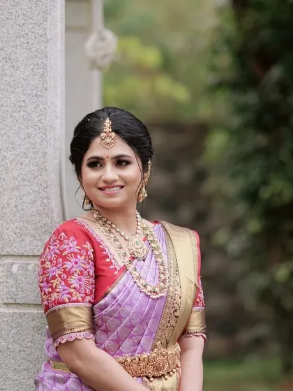 A beautiful bride wearing a custom red blouse with heavy floral embroidery on the puffed sleeves.