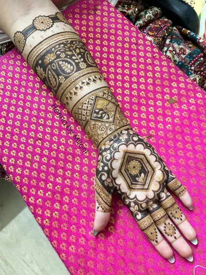 A full-arm design with a hexagonal floral motif on the palm, surrounded by paisley and geometric bands.