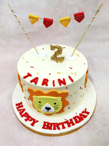We celebrate a little cub's birthday with this cheerful cartoon lion cake. A friendly lion face, festive bunting, and a glittering number "2" candle make this a bold and playful centerpiece for a jungle-themed party.