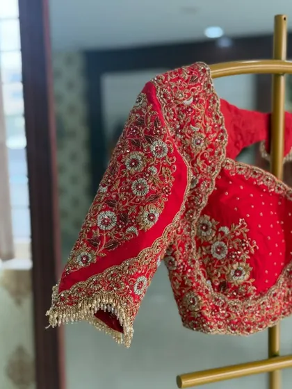 The sleeves of this red blouse are heavily embellished with pearl tassels.