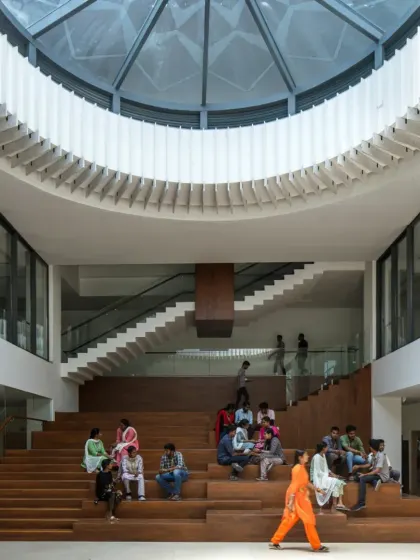 A full view of the multi-level staircase seating at Sona University, designed as an amphitheater-like space for social interaction. The large skylight above illuminates the area, making it a central point for student life and collaborative activities within the library block.