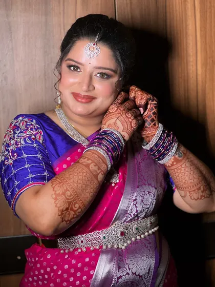 Another angle of the bride getting ready, showing her radiant smile and the flawless makeup application.