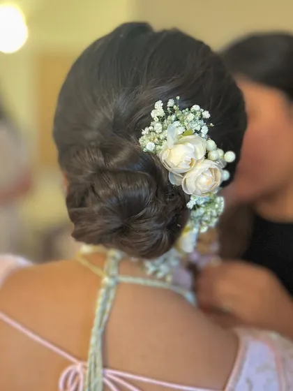 A closer look at the romantic floral bun, showing the delicate arrangement of the flowers.