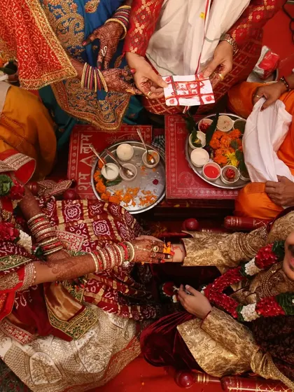 A beautiful moment from a wedding ceremony. The couple's hands, both adorned with mehndi, come together during a ritual.