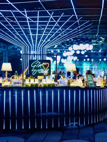 Another view of the futuristic "Gin O'Clock" bar, showcasing the glowing blue LED strips and the grid-like lighting installation on the ceiling.