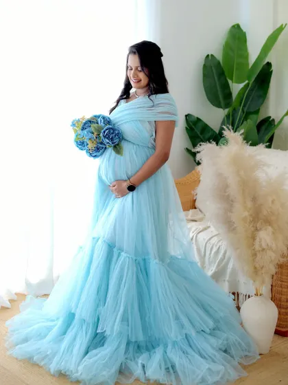 A portrait in our boho studio featuring a light blue gown and a bouquet of blue flowers, showing how we can coordinate props with your outfit.